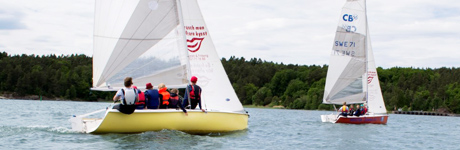 Två segelbåtar fulla med unga deltagare seglar i Vänern utanför Vänersborg.
