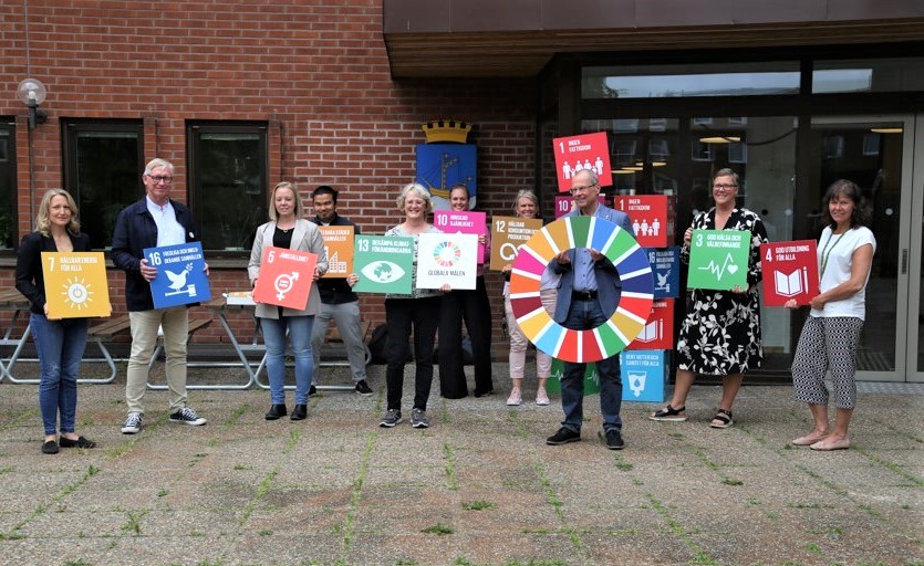 Bild föreställer personer i kommunen som håller upp de globala hållbarhetsmålen