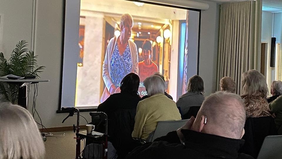 Bild från arrangemanget seniorbio där publiken tittar mot en storbildsskärm.