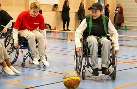 Ungdomar i rullstol jagar en basketboll.