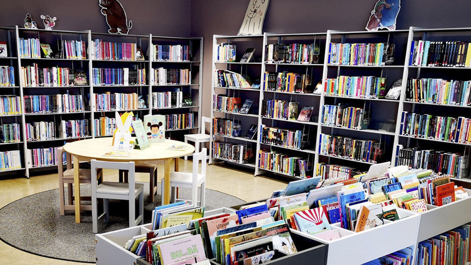 Bokhyllor med böcker omger en läshörna på biblioteket.