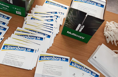 Utskrivna brev från Vänersborgs kommun ligger på ett skrivbord.
