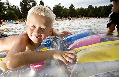Bilden föreställer ett barn som badar i Vänern