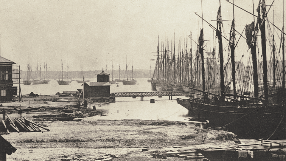 Der Hafen von Vänersborg mit links Rückstände der Werft bei Dyviken und dem Bahnhofsgebäude in Anbau, ca. 1865-1867