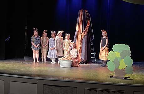 Teaterföreställning med flera barn utklädda till möss på scenen.