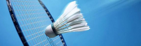 En badmintonboll träffar ett rack mot en blå bakgrund,.