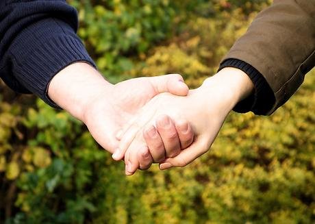 Två personer som håller varandras händer.