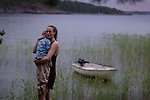 En kvinna vid vatten hållandes ett barn i sin famn. Fotot är hämtat från filmen.