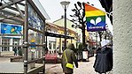Vy över gågatan med en regnbågsfärgad fasadflagga i förgrunden.