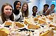 Glada ungdomar i ungivbg:s redaktion vid ett bord fyllt av tårta.